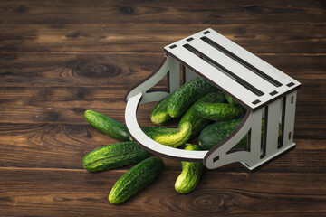 A box of cucumbers upside down on a wooden table.