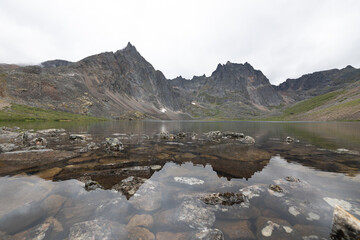 Landscape of Grizzly Lake in northern Canada, Yukon, sub arctic area with pristine water below massive mountain peaks. 