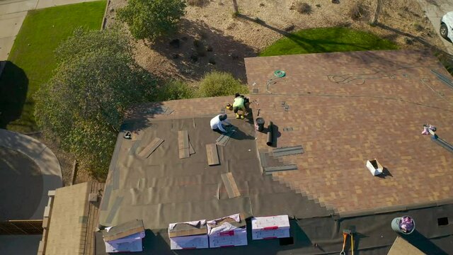 Men working on roof 4k drone video