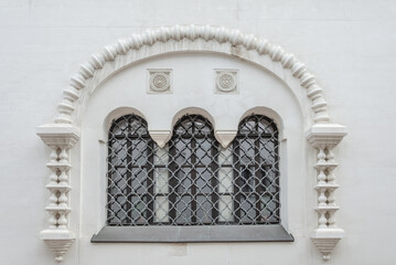 Windows with bars on the old wall.