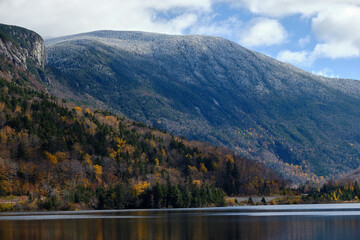 Autumn colors along the granite shoreline and mountains of Echo Lake in New Hampshire