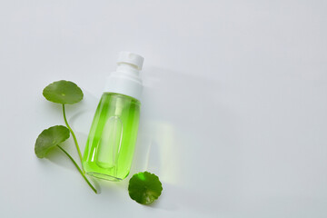Cosmetic bottle containers with centella asiatica (gotu kola)  extract top view. Close-up and white decoration background. The blank label for mock up. 