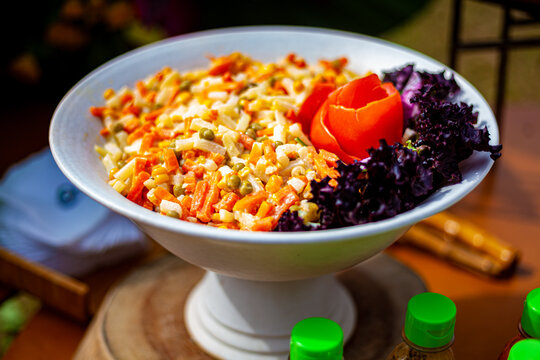 Vaso branco com salada de milho, ervilha, cenoura, tomate, alface roxa e queijo