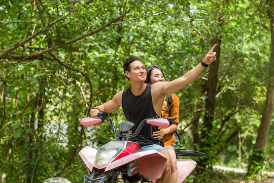 Young Man And Woman Driving Off Road Adventure With Happy And Smiling. Couple Riding On ATV Bike Or Quad Bike On Road Along Forest Trail On Mountain. Camping, Jungle Adventure Concept