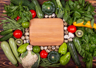 Various vegetables wooden background, top view, flat layout. Concept of healthy eating, food background with a border of fresh vegetables. Frame of vegetables with space for text. Fresh vegetables