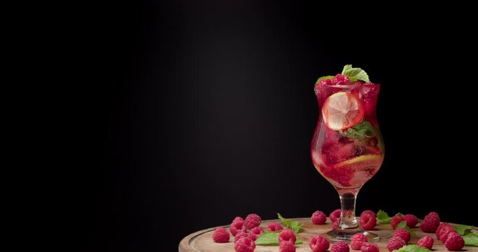 Glass of fresh raspberry lemonade on dark background