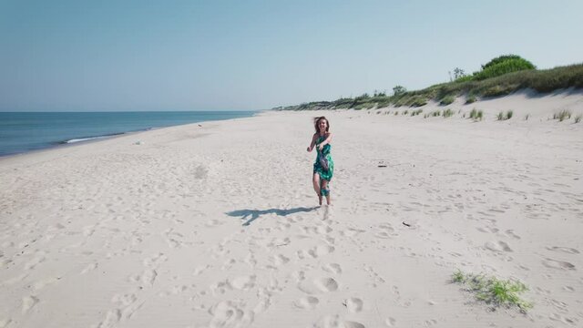 Aerial view. Beautiful woman in a blue dress on the shore of the baltic sea.