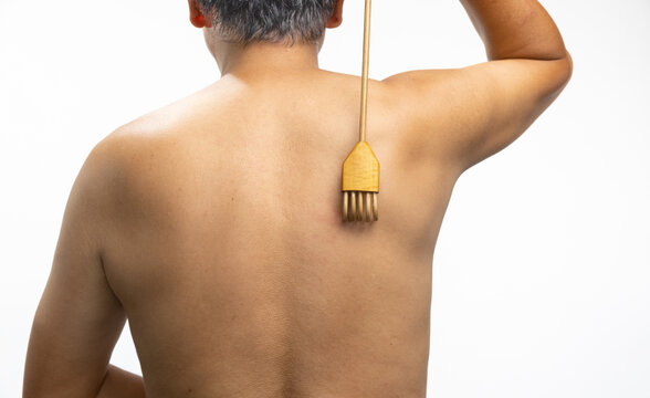 Senior man scratching his back with a back scratcher.