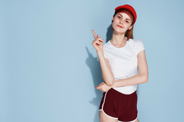 Fototapeta na wymiar cute girl in red cap makeup summer clothes fashion blue background