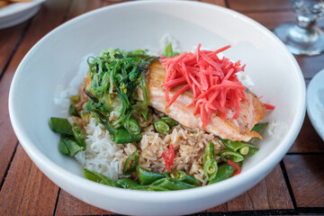 A bowl with salmon, ginger, peas and rice