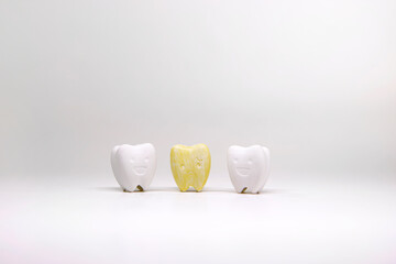 Yellow tooth between smile whitening teeth on white background, Yellow teeth that cause a loss of...