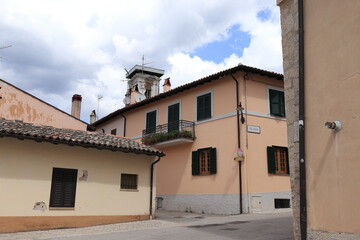 Fototapeta na wymiar Norcia Street View with Pink Buildings and Damaged Tower, Italy