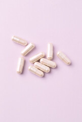Carnitine capsules. Concept for a healthy dietary supplementation. Bright paper background. Top view. 