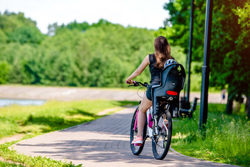 Naklejka premium A woman and her son ride bicycle in the park 