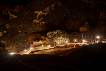 The wooden walking path with lighting in the big cave at Satun Province in Thailand