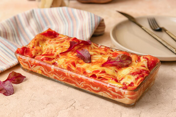 Baking dish with tasty tomato lasagna on light background