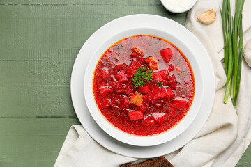Bowl with tasty borscht on color wooden background