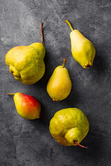 Several ripe pears on gray background top view, trending ugly fruits vertical photo