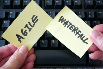 waterfall vs agile paper task on keyboard background, software development methodologies concept