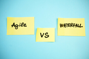 waterfall vs agile paper task on blue background, software development methodologies concept