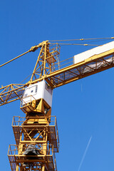 High tower construction crane with blue sky background.
