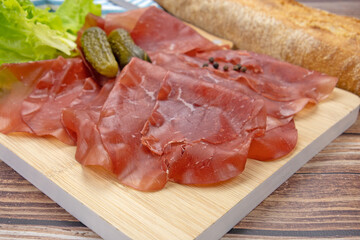 tranches de bresaola sur une planche à découper	