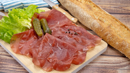 tranches de bresaola sur une planche à découper	