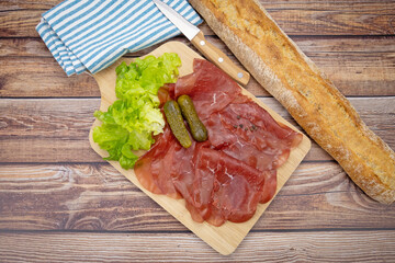 tranches de bresaola sur une planche à découper	