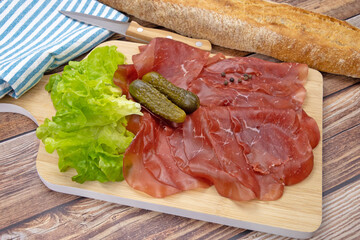 tranches de bresaola sur une planche à découper	