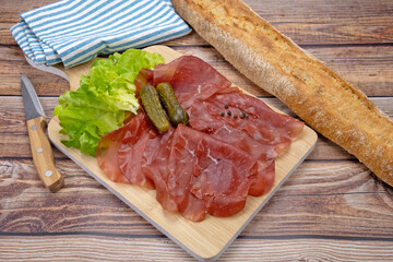 tranches de bresaola sur une planche à découper	