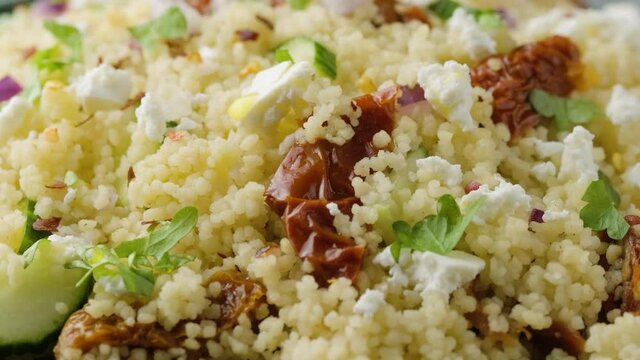 Couscous salad with sun dried tomatoes, cucumber, red onion and feta cheese. healthy food.