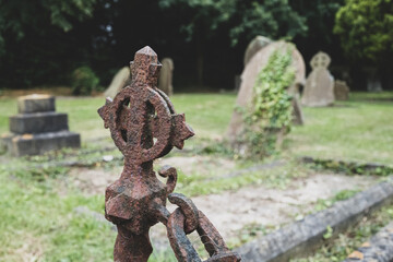Close-up of a wrought Iron chain linked fence seen at the edge of a grave in a typical cemetery....