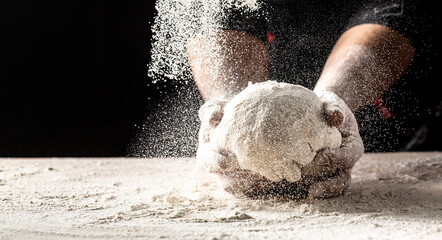 Hands of baker kneading dough isolated on black background. prepares ecologically natural pastries