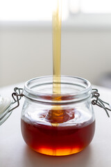 fresh natural buckwheat honey is poured into a jar