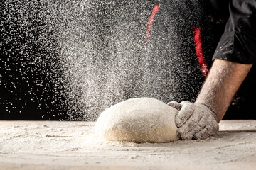 Male hands making dough for pizza. Beautiful and strong men's hands knead the dough make bread, pasta or pizza