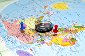 a compass lying on a geographical map buttons mark the place of travel the concept of a tourist