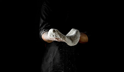 Clap hands of baker with flour. Beautiful and strong men's hands knead the dough make bread, pasta or pizza. Powdery flour flying into air