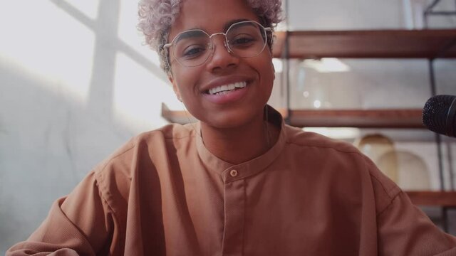 Close up webcam view of young African American female blogger waving hand welcoming people. Beautiful stylish woman with short curly hair starting video recording on her blog. Online meeting concept
