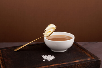 Tibetan butter tea or churned tea in white bowl on cutting board, close-up. Asian drink known as...