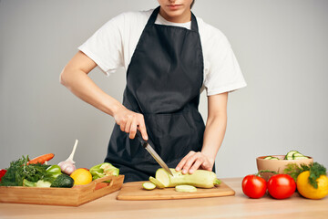 housewife in the kitchen cutting vegetables on a cutting board vitamins