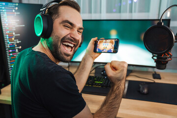 Young man gamer playing video games on smartphone © Drobot Dean