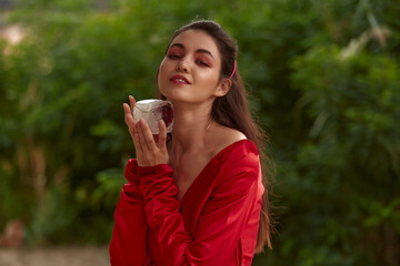 Fototapeta premium Ritual dance with candles in hands. Brunette woman in red costume for belly-dance is dancing on the beach