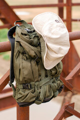 a tourist's backpack and hat hang on the railing of the old iron bridge over the river concept of travel tourism