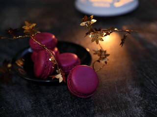 Macaroons and lantern moody food background.