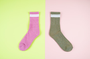 Multicolored socks on a pastel multi-colored pink and green background