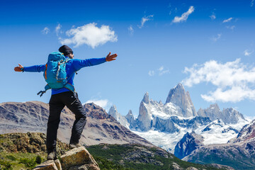 Active hiker hiking, enjoying the view, looking at Patagonia mountain landscape. Fitz Roy, Argentina. Mountaineering sport lifestyle concept - obrazy, fototapety, plakaty