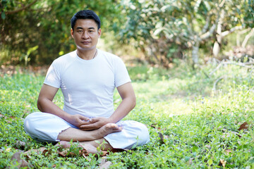 Naklejka na ściany i meble Man sits and doing yoga meditation. Concept : Peaceful ,calm, healthy lifestyle and strong soul and body. Relax and recreation activity for happy life.