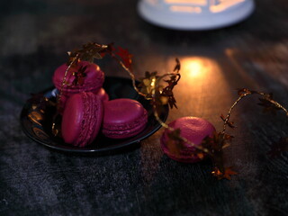 Macaroons and lantern moody food background.