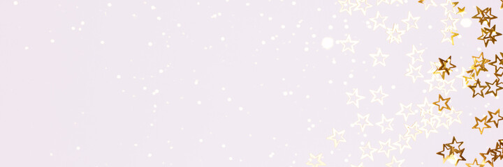 Banner with glowing gold stars confetti on a white background with copyspace.