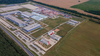 Modern exterior of industrial complex at daytime. Aerial view of manufacturing structure with parking for machinery outdoors. Industrial concept.